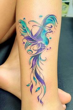 a woman's leg with a colorful tattoo on the side of her body and an image of a bird