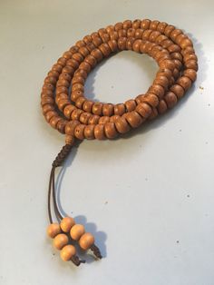 Nepal Bodhi Seed Mala with Sandalwood end beads and an adjustable knot. 108 bead necklace with Phoenix Eye guru bead for Japa Mala Brown Beaded Necklaces For Meditation And Festivals, Holistic Wooden Beads For Festivals, Brown 8mm Beads Mala For Festival, Brown Mala With 8mm Beads For Festival, Holistic Brown Mala With Wooden Beads, Brown Wooden Beads For Festivals, Traditional Brown Hand Knotted Necklace, Holistic Wooden Beads Mala For Festivals, Hand-strung Adjustable Mala For Festivals