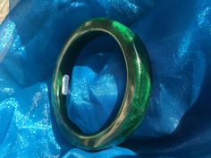 62.44mm Thick Jadeite Green Uncarved Heavy Jade Bangle #965 Dimensions:  62.44mm x 12.32mm x 8.87mm This is a heavier bangle of the type usually used in carving styles.  It has a dense spinach, deep forest green, is really nice. We tested this piece, and it tested as jadeite jade.  The photo here coincides with testing this bangle, but does not come with a professional gem certificate. Please ask questions prior to purchase for best experience and results. Green Carved Bracelet As A Gift, Green Carved Bracelets As Gift, Green Carved Bracelet For Gift, Handmade Green Jade Bangle, Green Bangle For Collectible Jewelry, Green Bangle Collectible Jewelry, Green Bangle Jewelry Collectible, Elegant Carved Green Bangle, Elegant Green Carved Bangle