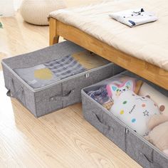 two storage bins with stuffed animals in them on the floor next to a bed