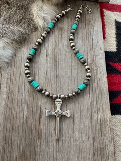 Simple yet powerful, a true labor of love! ~ Limited Quantity ~~ This awesome cross was made by an artist from vintage nails, sand-cast in white bronze sterling silver, hand stamped, and wire wrapped! ~Graced with a Lovely Strand of Navajo Handmade Pearls with Pumpkin Beads and turquoise Handmade by Navajo Artists exclusively for Navajo Pearls Ranch!~Choose Your Length ~Each bead is heavily plated in .925 sterling silver, hand polished & antiqued, creating a perfect handmade Navajo Pearl.You won Traditional Adjustable Cross Jewelry, Bohemian Cross Jewelry For Healing, Vintage Cross Jewelry With 8mm Beads, Artisan Adjustable Cross Jewelry, Vintage Cross Necklace With 8mm Beads, Vintage Cross Necklaces With 8mm Beads, Handmade Healing Cross Jewelry, Artisan Cross Jewelry For Jewelry Making, Artisan Cross Necklace For Jewelry Making