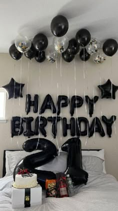 a birthday party with balloons and presents on the bed