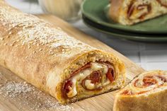 a close up of a burrito cut in half on a cutting board next to other food items