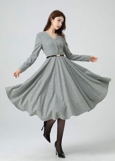 Stay stylishly snug this winter with a light grey wool swing dress. This dress is cinched at the waist with a hemline that can also be turned up beautifully, and has a buttoned front to accent the v-neck. Pair this dress with heeled ankle boots for a sophisticated look. Details: * 30% wool, 30% fiber, 40% polyester * fully satiny lining, more nice to the touch body * V neckline dress * Long sleeves dress * Two side seam pockets * Right zipper closure * Button front * Fit and flare dress * Midi w Gray A-line Winter Dresses, Knee-length Buttoned Midi Dress For Winter, Winter Knee-length Midi Dress With Buttons, Classic V-neck Winter Dress, Winter A-line Midi Dress With Buttons, Classic A-line Winter Dress, Winter Wool Knee-length Midi Dress, Winter V-neck Midi Dress For Workwear, Wool Long Sleeve Midi Dress For Spring