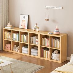 there is a book shelf with many books on it in the living room and children's toys