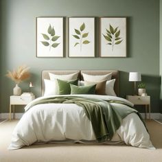 a bedroom with green walls and white bedding, two framed pictures above the bed