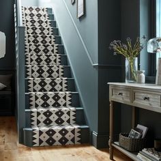 the stairs are decorated with black and white tiles on them, as well as flowers in vases