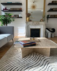 a living room filled with furniture and a fire place in front of a mirror on the wall