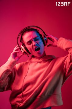 Portrait of a young woman in headphones listening to music on a pink background Headphones Listening To Music, Neon Backgrounds, Pink Background, Listening To Music, Pretty Woman, Headphones, Lost