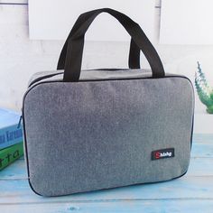 a gray bag sitting on top of a wooden table