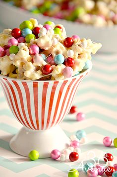 a bowl filled with lots of candy and marshmallows on top of a table