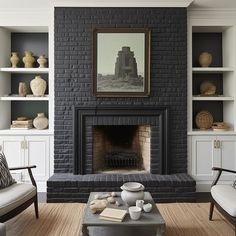 a living room filled with furniture and a fire place in front of a brick fireplace