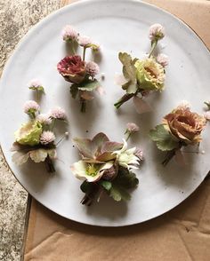 small flowers are placed on a white plate