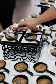 a table topped with trays of cookies and muffins