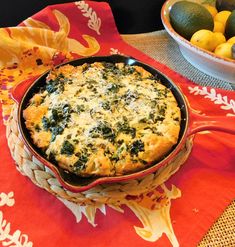 a casserole with spinach and cheese in a bowl next to lemons