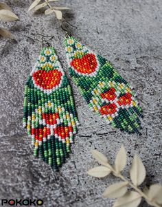 the beaded earrings are made with seed beads and decorated with red, green and yellow flowers