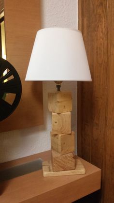 a lamp that is sitting on top of a wooden table next to a wall mounted clock