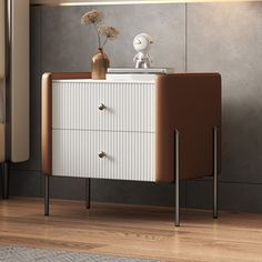 an orange and white chest of drawers next to a lamp on a wooden floor in a room