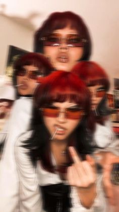 a group of women with red hair and sunglasses making the peace sign while standing in front of them