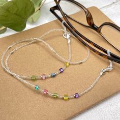 Colorful and bohemian eye glasses necklace chain in crystal clear tones with delicate multicolor flashes and silver notes, featuring small cubic zirconia charms. The necklace is made with Preciosa Czech crystal seed beads, tiny silver plated crystal seed beads and delicate colorful cubic zirconia crystal beads. Paired with tiny, delicate silver plated crystal beads, this handmade eyeglass chain will definitely create a unique look. This eyeglass lanyard is made on strong quality beading wire wit Adjustable Iridescent Glass Jewelry, Beaded Clear Glass Glasses Chains, Clear Beaded Glass Glasses Chains, Adjustable Glass Beaded Necklaces For Party, Trendy Silver Glass Necklace, Summer Crystal Jewelry As A Gift, Adjustable Glass Necklaces With Tiny Beads, Adjustable Rainbow Glass Necklaces, Adjustable Glass Necklace With Tiny Beads