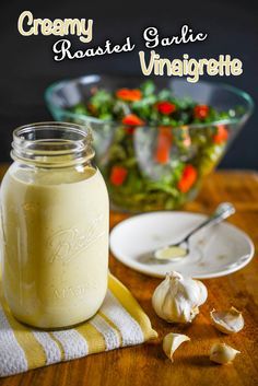 a glass jar filled with dressing next to a salad