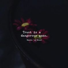 the words trust is a dangerous game written on a black plate with red daisies