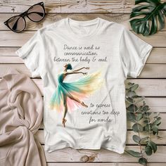 a t - shirt with the quote dance is need as commension between the body and soul