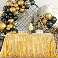 a table topped with black and gold balloons