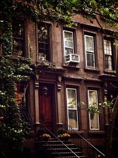 an old brownstone building with many windows and stairs