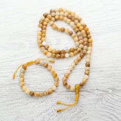 Harness the warmth and powerful energy of the sun with this golden Yellow Jade 108 bead mala necklace handcrafted in Kathmandu. This mala emits a sunny yellow energy and helps to rejuvenate the Solar Plexus Chakra that enables you to feel joyful, warm and energetic. Whether you wear it around your neck or wrap it around your wrist, Yellow Jade is believed to bring good fortune, happiness, and self-confidence to those who carry it. Yellow Jade is is a motivational stone that encourages expression Yellow Spiritual Beaded Necklace With Gemstone Beads, Amber Beaded Bracelets For Meditation, Hand-strung Amber Beaded Bracelets For Meditation, Yellow Hand-strung Jewelry For Meditation, Adjustable Natural Stones Mala For Meditation, Gold Healing Mala With 108 Beads, Spiritual Hand-strung Amber Beaded Necklaces, Gold Mala With 108 Beads For Healing, 8mm Amber Beads For Spiritual Use