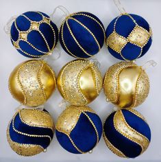 blue and gold ornaments are arranged on a white surface