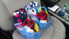 two blue baskets filled with items in the back seat of a car