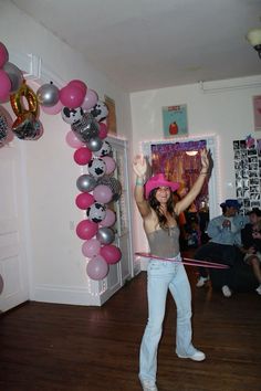 a woman is dancing in a room with balloons