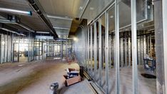 the inside of an industrial building with lots of glass walls and steel studs on the wall