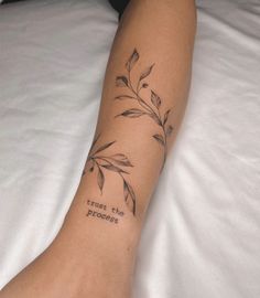 a woman's leg with a tattoo saying trust the process on her left arm