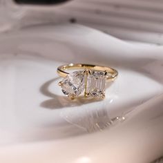 two stone ring sitting on top of a white plate