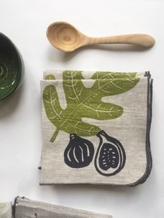 an assortment of kitchen utensils on a white surface with a green leafy design