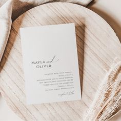 a close up of a wedding program on a wooden platter with a white napkin