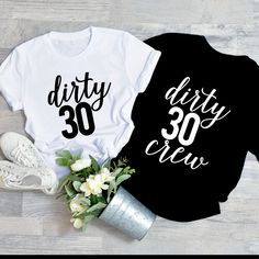 two shirts that say dirty thirty and 30 are next to some flowers on the floor