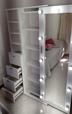 a large lighted mirror in the corner of a room with a bed and dresser underneath it