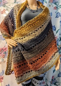 a mannequin wearing a multicolored crocheted shawl