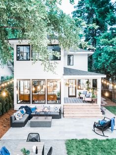 an outdoor patio is lit up with string lights and seating for the guests to sit on