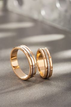 two gold wedding bands with diamonds on them