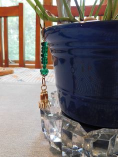 a potted plant sitting on top of a table next to a crystal block with beads hanging from it