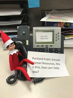 an elf is sitting on the telephone with a sign that says portland public schools human resources, this is kris, how can i help you?