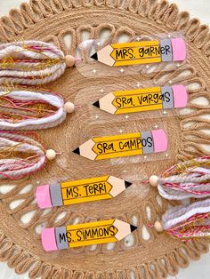 several pencils with writing on them sitting on a doily that says ms simon's teacher