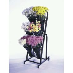 a cart with flowers on it is holding several different types of flowers and the wheels are black