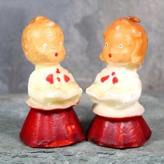 two little figurines sitting on top of each other