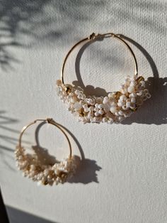 The stunning statement 'AMARA' earrings are crafted with inspiration drawn from the serene seaside and its golden beaches. These earrings are made with lustrous white Miyuki seed beads, natural white Jade chip beads, and Czech gold fire-polished crystal beads, hand-wired meticulously into waves and attached to 45mm gold plated hoops.  Due to hygienic reasons, I cannot accept refunds or exchanges for 'Amara' earrings as they are made to order. However, if you encounter any issues with your order, please do not hesitate to contact me, and I will gladly assist you. Elegant Small Hoop Earrings For Beach, White Hoop Bridal Earrings, Gold Beaded Hoop Earrings For The Beach, Delicate Handmade White Hoop Earrings, White 14k Gold Filled Hoop Earrings, Handmade Small Hoop Earrings For Wedding, White Pearl Drop Hoop Earrings In 14k Gold, Elegant White Hoop Earrings For Beach, White 14k Gold Filled Hoop Jewelry