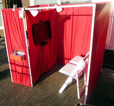 a red tent with a white chair in front of it